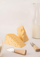 cheese and milk on the table. a bottle of fresh milk and yellow emmental cheese on the dining table. dairy products in the kitchen