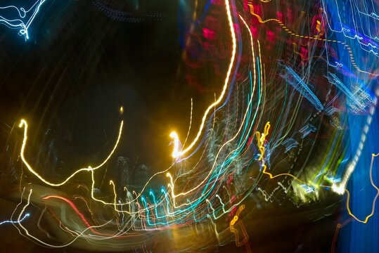 Light trails of urban traffic. Light painting. Neon glow. Symmetry and reflection. Festive decoration. Abstract blurred background. Glowing texture. Shining pattern. Abstract Night City Lights. High