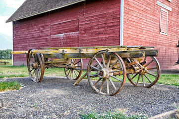 Old wagon next to red barn