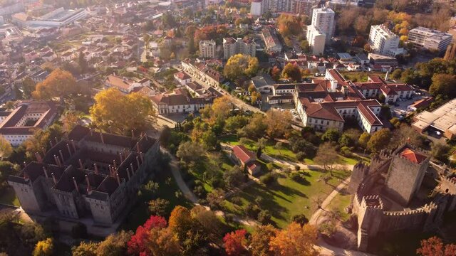 Drone fly above guimares Portugal city old medieval town with castle and cathedral during golden hours