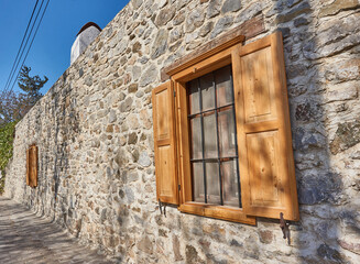 Country house wooden window in stone wall