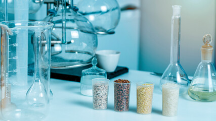 Chemical tubes, petri dishes, glass vials. Millet, rice, buckwheat, pearl barley in the laboratory for food quality control of grain crops. Various varieties of cereals in a food laboratory.