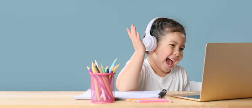 A Happy little asian girl studying online learning class with online video call zoom teacher at home. E-learning or Home schooling education concept. New normal.Covid-19 coronavirus.Social distancing.