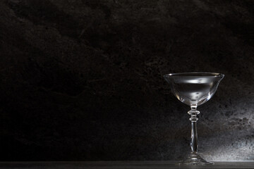 Empty cocktail glasses and containers in front of a dark marble tile background