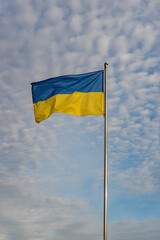 A Symbol of Freedom, Ukraine's Flag Waves in the Cloudy Blue Sky