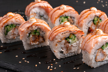 Traditional delicious fresh baked Philadelphia sushi roll set on a black background. Japanese...
