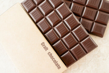Handmade chocolate bar copy space. Black bitter craft chocolate on white background. Healthy food concept, delicious chocolate sweets, diet, sugar