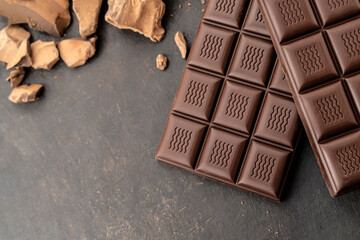 Handmade chocolate bar copy space. Black bitter craft chocolate on white background. Healthy food concept, delicious chocolate sweets, diet, sugar