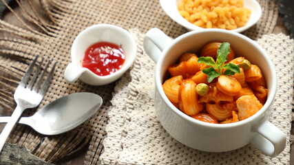 Macaroni in white cup with tomato sauce