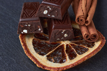 Dark chocolate bars with chopped almonds, dried orange wedges
