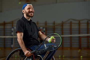 Young man in wheelchair playing tennis on court
