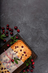 Christmas spicy cake with berries, decorated with cranberries on the black background top view vertical format. Christmas Background for invitations, greeting card, postcard. Recipe tasty homemade