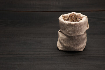  pouch full of Organic natural chia seeds on dark wooden background or table