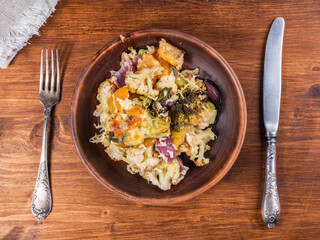 Baked vegetables with cheese - portion in a plate, top view