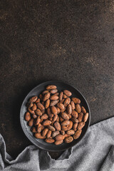 Obraz na płótnie Canvas Dried cocoa beans. Cacao beans on plate.