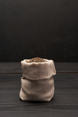 Fototapeta na wymiar pouch full of Organic natural chia seeds on dark wooden background or table