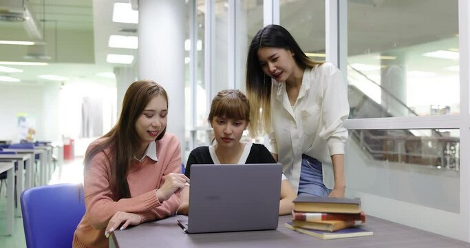 Group of Asian college student girl meeting and making education project together in library.