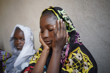 Two black African girls with a sad and worried expression on their faces anticipating an uncertain...