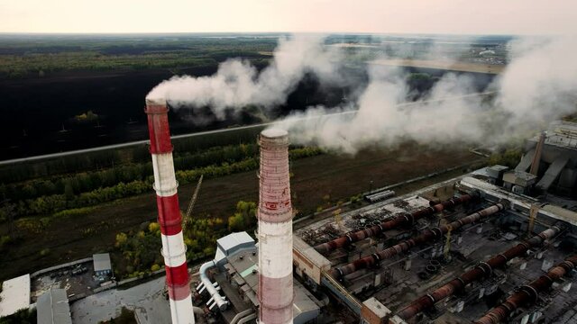 Epic aerial of high smoke stack emission. Plant pipes pollute atmosphere. Industrial factory pollution, smokestack exhaust gases. Industry zone, thick smoke plumes. Climate change, ecology