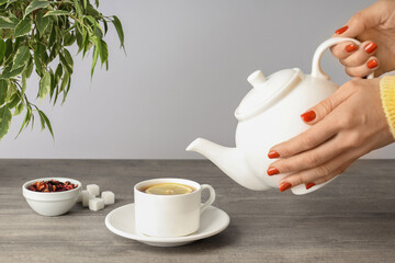 Concept of hot drink with tea on gray wooden table