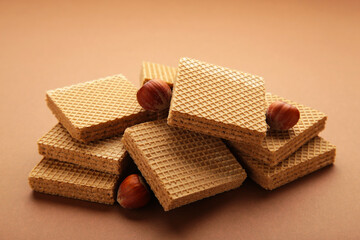 Chocolate wafers on brown background with hazelnut.