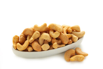 Cashew nuts on white plate isolated on white background. Top view.