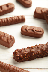 Mix of chocolate bars on white wooden background. Top view.