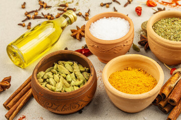 A set of spices for cooking curry. Aromatic condiments on light stone concrete background