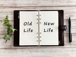 白板の上で開いた手帳とボールペンとツタ_俯瞰_OldLifeとNewLife文字入り