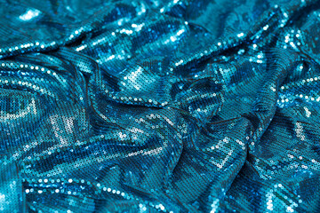 Fabric with sequins as a background. Glittery texture is the trend of the season. Sparkling color holographic blue, pink.