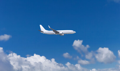 White airplane flying on the blue sky.