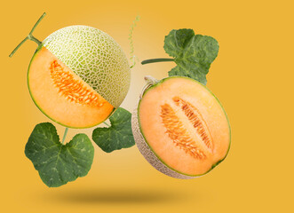 Sweet melon or cantaloupe with leaves falling in the air isolated on  yellow background, Japanese...