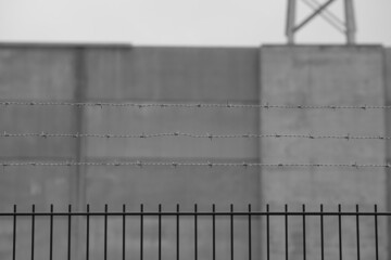 Zaun und Mauer als Sicherung vor Einbruch und Verwüstung, Bauwerk einer bedeutenden Infrastruktur Einrichtung oder einer befestigten Staatsgrenze - obrazy, fototapety, plakaty