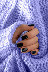 Female manicure with gel polish, background of trendy purple color.