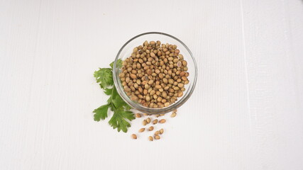 Dry coriander seeds with small bamboo spoon and green fresh bunch coriander leaves,famous spices ingredients in asia's kitchen.