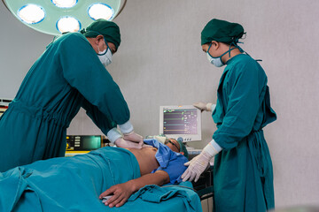 Selective focus at defibrillator while doctor use it to pump at chest of unconscious with low heart rate patient to save life while doing medical surgery inside of operating room. Emergency aid, CPR.