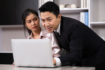 Selective focus at face of young beautiful women office worker sitting with hand of men touch her body. Sexual harassment in workplace concept.