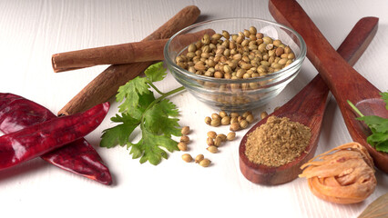 Dry coriander seeds with small bamboo spoon and green fresh bunch coriander leaves,famous spices ingredients in asia's kitchen.