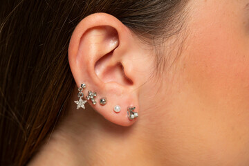 ear piercings photos.Helix piercing.Ear rings - obrazy, fototapety, plakaty