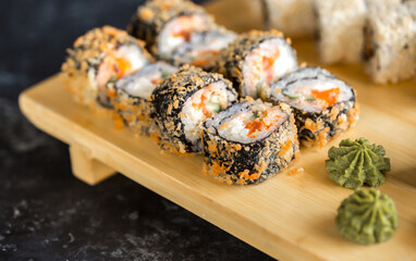 Sushi rolls Japanese delicacies. Japanese traditional rice and fish dishes. Beautiful serving food on a dark background with copy space. A set of delicious goodies.