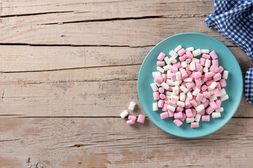 Sweet marshmallows topping on wooden table. Top view. Copy space