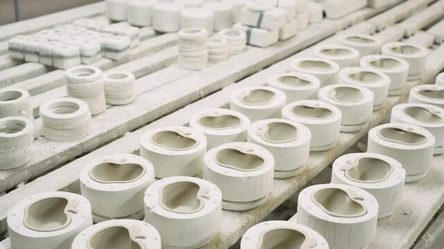 Production of gypsum molds for casting porcelain products by conveyor method at the factory. Manufacture of apple-shaped porcelain tableware and other products. Professional poring polymer material