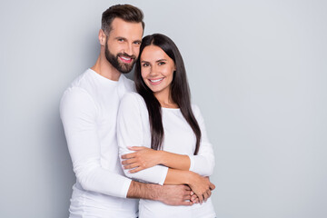 Photo of cute young couple embrace wear white shirt isolated on grey color background