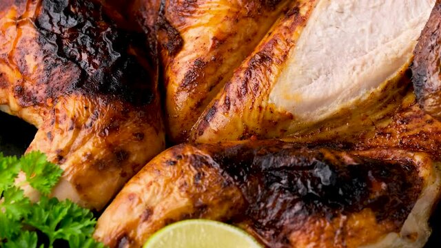 Roast Chicken Tabaka, tobacco with lime on black plate. Closeup rotating video