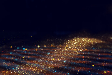 background of abstract gold and black glitter lights. defocused