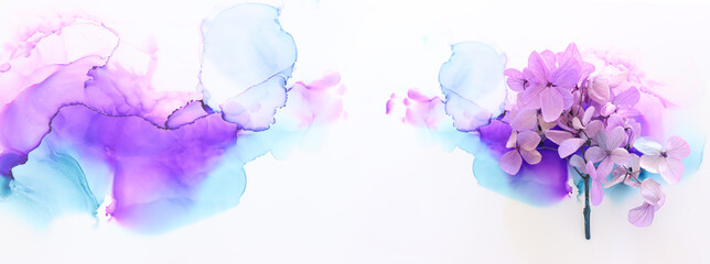 Creative image of pastel violet and pink Hydrangea flowers on artistic ink background. Top view...