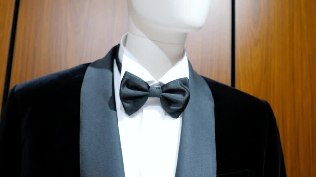 Mannequin in black tailcoat and bow tie. Expensive clothing store. Close-up