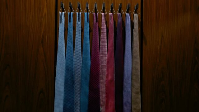 Multi-colored ties hang in the shop window. Men's clothing boutique.