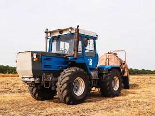 Blue powerful tractor on the field