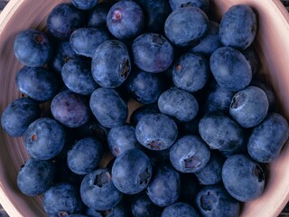 Background with blueberries in a clay bowl. Close-up, flat lay